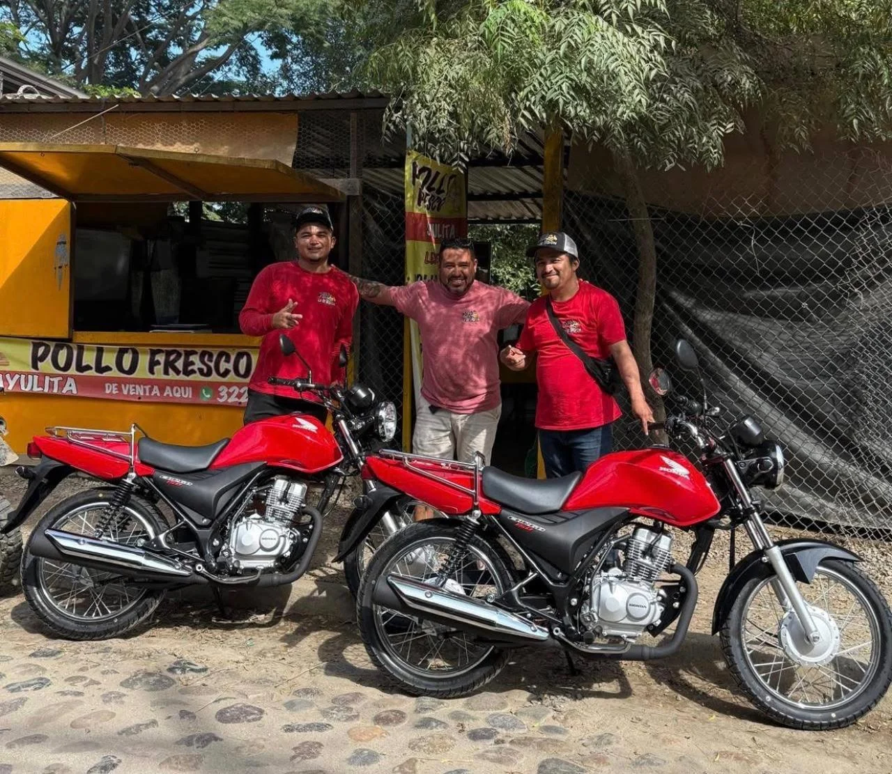 Equipo de Pollo Fresco Sayulita junto a sus motocicletas frente al local.